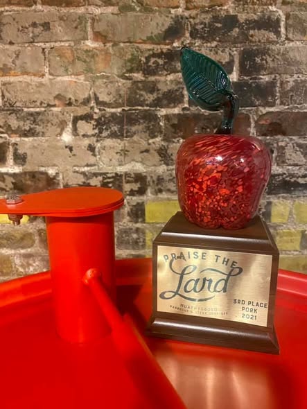 A single red glass-apple trophy from Praise the Lard