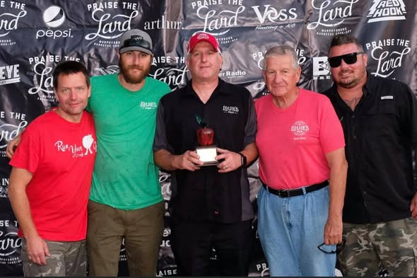 The Louie's BBQ crew posing in front of the Praise the Lard backdrop