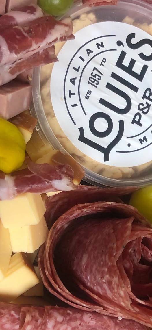 Charcuterie board with salami, cheeses, and peppers